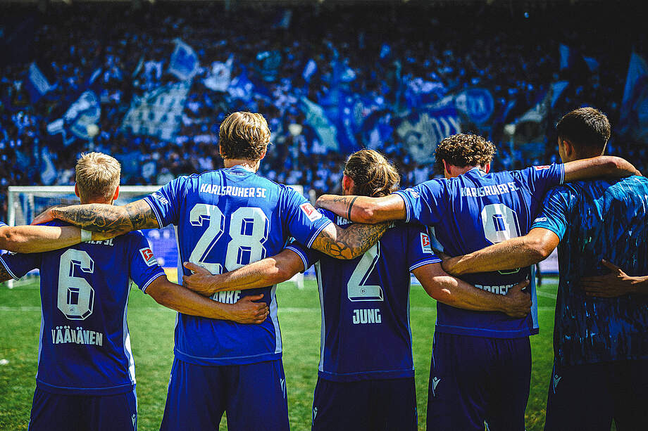 KSC-Spieler Arm in Arm vor den Fans