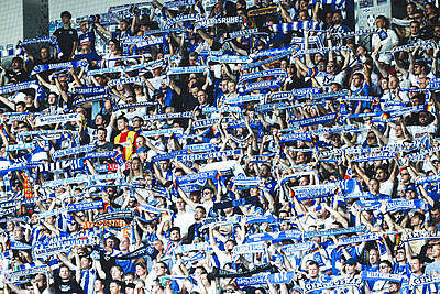 Fans halten ihre Schals im Stadion hoch.