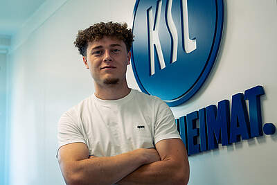 Philipp Sonn vor dem KSC-Logo nach seiner Unterschrift