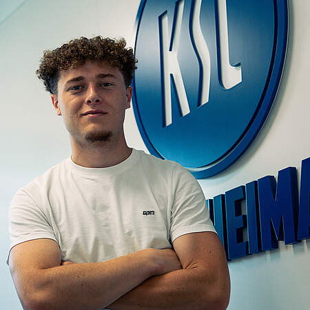 Philipp Sonn vor dem KSC-Logo nach seiner Unterschrift