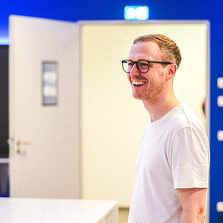Maximilian Senft steht lächelnd in der KSC-Kabine.