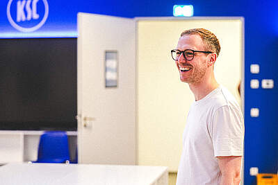 Maximilian Senft steht lächelnd in der KSC-Kabine.