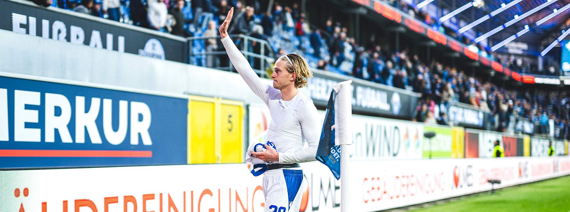 David Herold hat sein Trikot ausgezogen und winkt zu den Fans.
