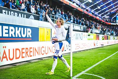 David Herold hat sein Trikot ausgezogen und winkt zu den Fans.