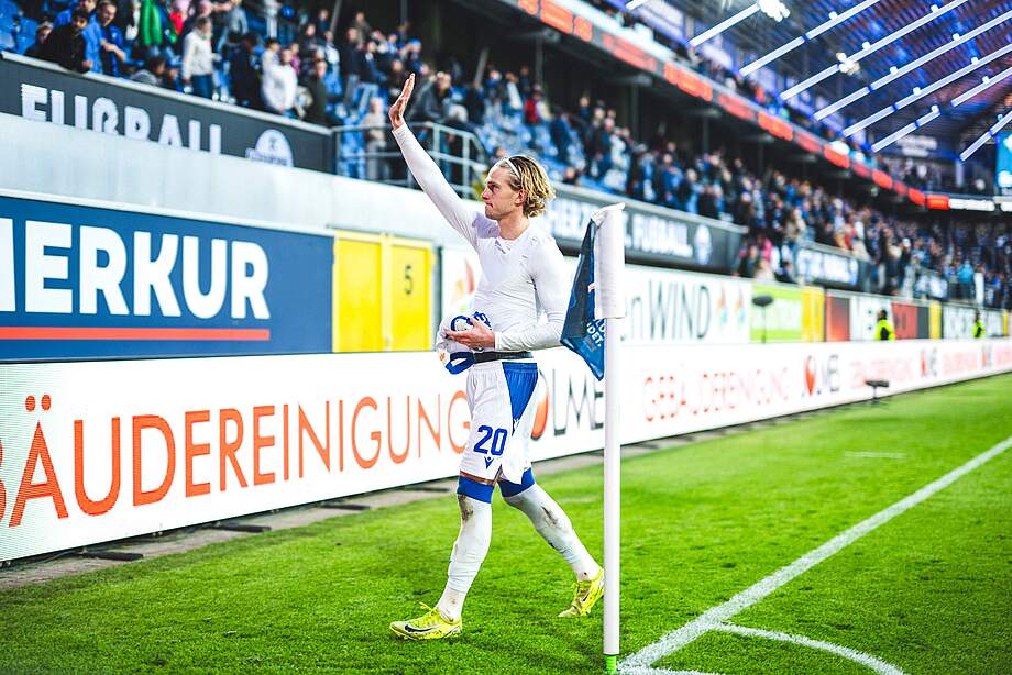 David Herold hat sein Trikot ausgezogen und winkt zu den Fans.