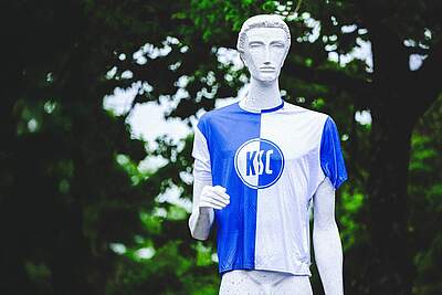 Der Nackte Mann trägt das blau-weiße KSC-Fanshirt