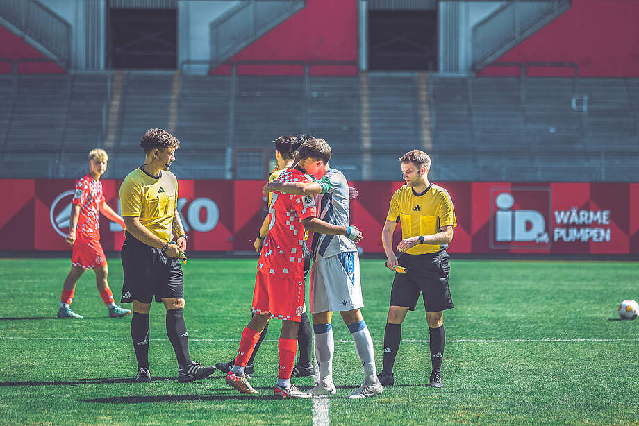 U19 Kapitän Mateo Kritzer umarmt den Kapitän der Hessen vor dem Spiel.