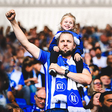 Ein Fan steht mit seiner Tochter auf den Schultern im BBBank Wildpark
