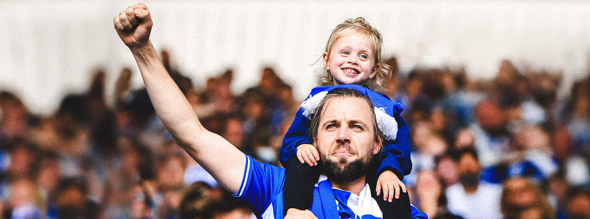 Ein Fan steht mit seiner Tochter auf den Schultern im BBBank Wildpark