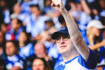 Ein Fan im BBBank Wildparkr reckt den Arm zum Jubel.