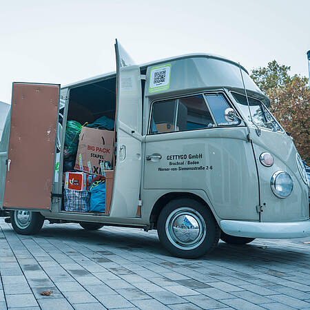 Ein kultiger Bus beladen mit Kisten voller Kleiderspenden.