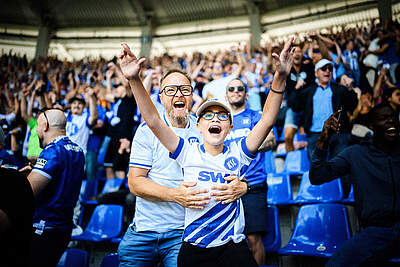 Zwei Fans im BBBank Wildpark jubeln