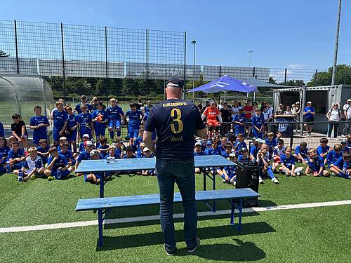 Burkhard Reich vor den Kids der Fußballschule