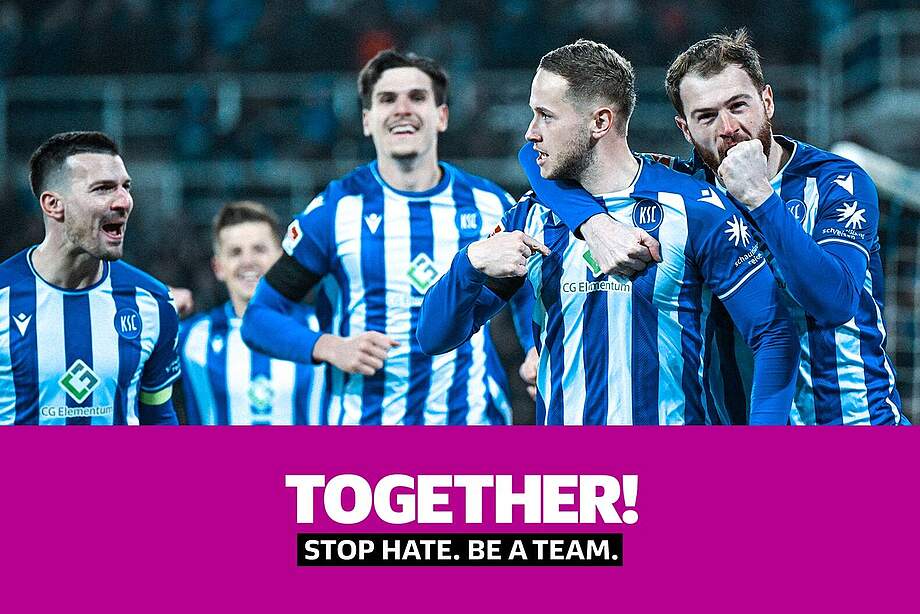 KSC-Spieler jubeln gemeinsam im Heimtrikot. Darüber hinaus wird die Botschaft des Aktionsspieltags "TOGETHER!" abgebildet. Diese lautet "STOP HATE. BE A TEAM.".