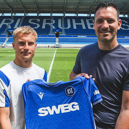 Neuzugang Viktor Bergh (li.) und Geschäftsführer Sport Mario Eggimann mit einem KSC-Trikot in der Hand.