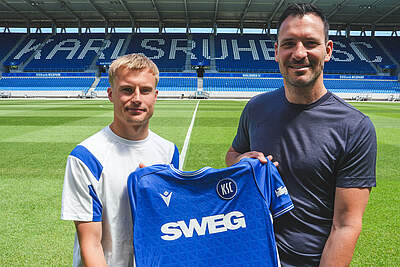 Neuzugang Viktor Bergh (li.) und Geschäftsführer Sport Mario Eggimann mit einem KSC-Trikot in der Hand.