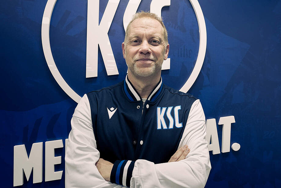 U23 Cheftrainer Dietmar Blicker vor dem KSC-Logo