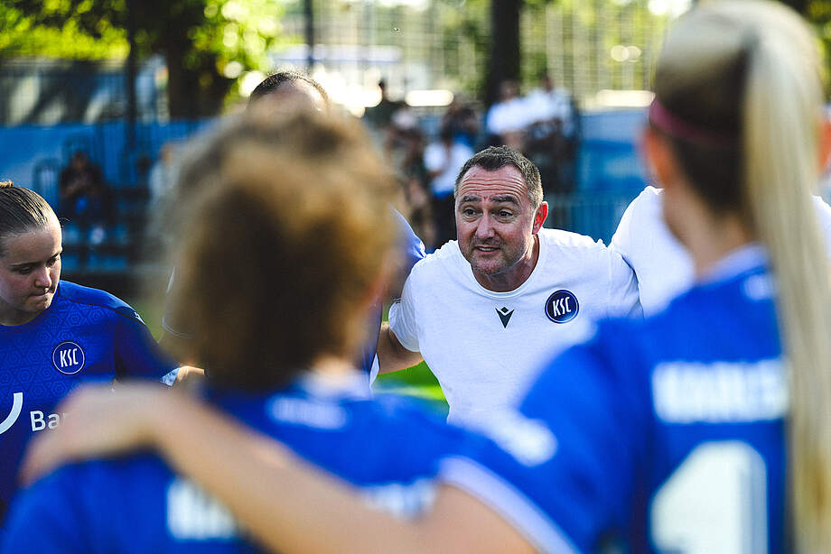 Christopher Holz spricht im Teamkreis zu seiner Mannschaft.