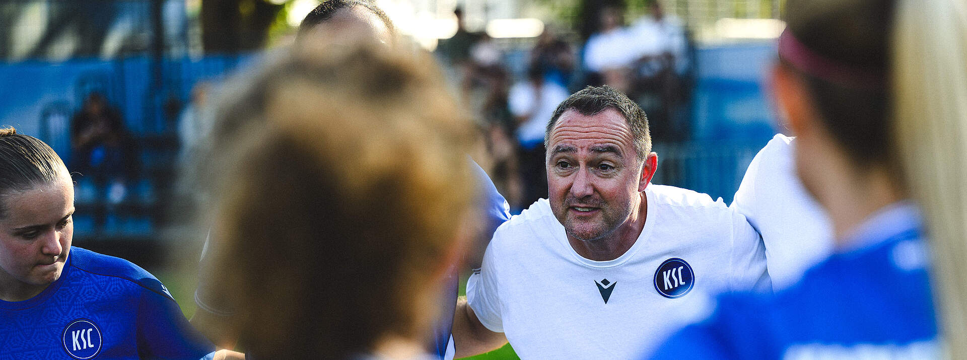 Trainer Christopher Holzer spricht im Teamkreis zu seiner Mannschaft.