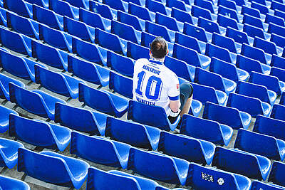Ein Fan im Trikot sitzt auf einem Sitz im BBBank Wildpark
