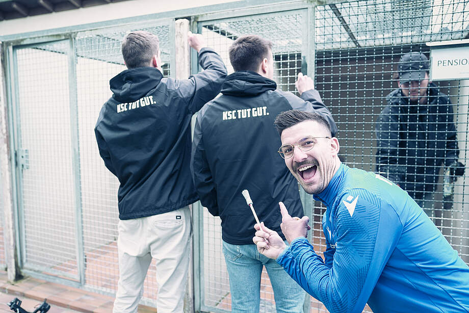 Zwei Helfer von KSC TUT GUT. und Jerome Gondorf gut gelaunt