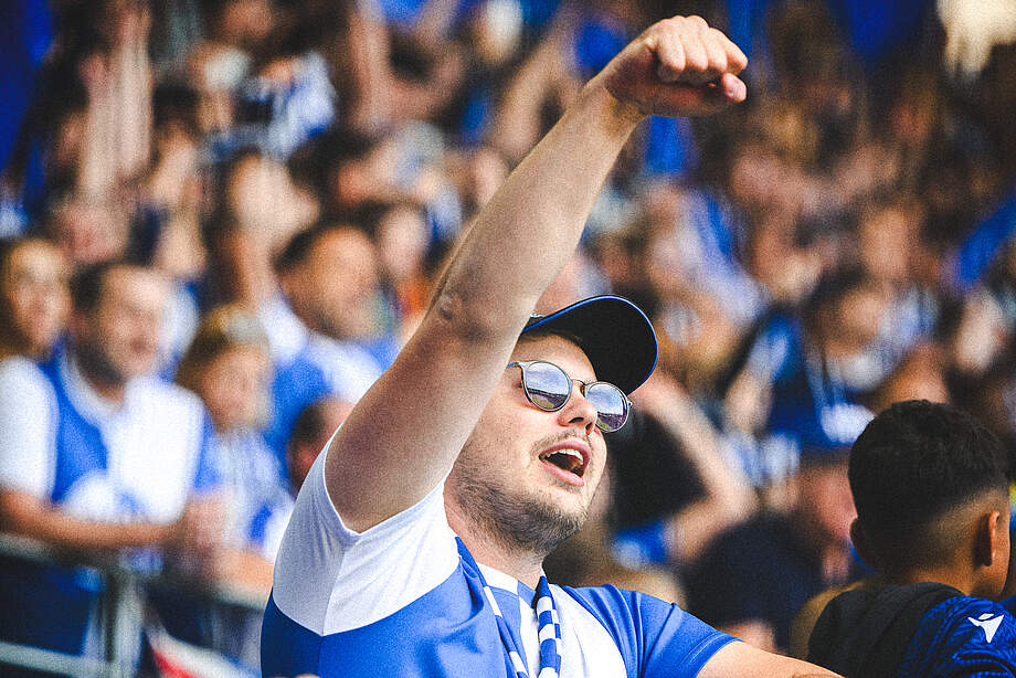Ein Fan im BBBank Wildpark reckt seine Faust in die Höhe.
