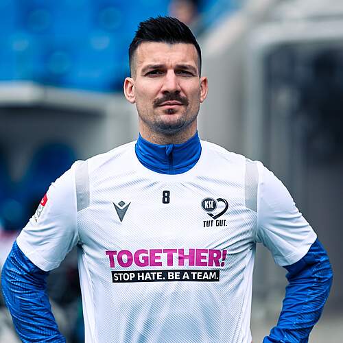 Jerôme Gondorf im Aufwärmshirt mit dem Schriftzug "TOGETHER" STOP HATE. BE A TEAM."