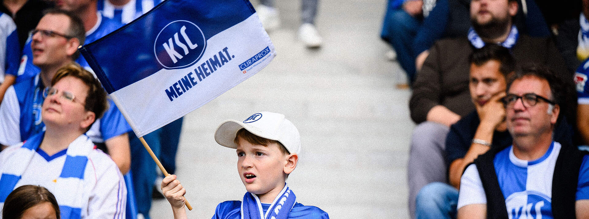 Ein Junge im BBBank Wildpark schwenkt eine KSC-Fahne