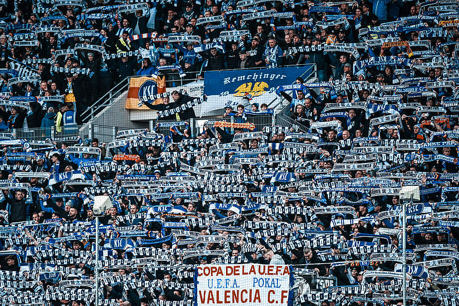 Die Gegengerade hält ihre Schals hoch.