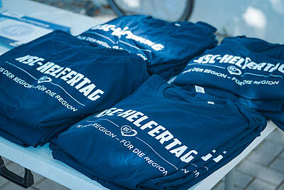 T-Shirts vom KSC-Helfertag ausgebreitet auf einem Tisch.